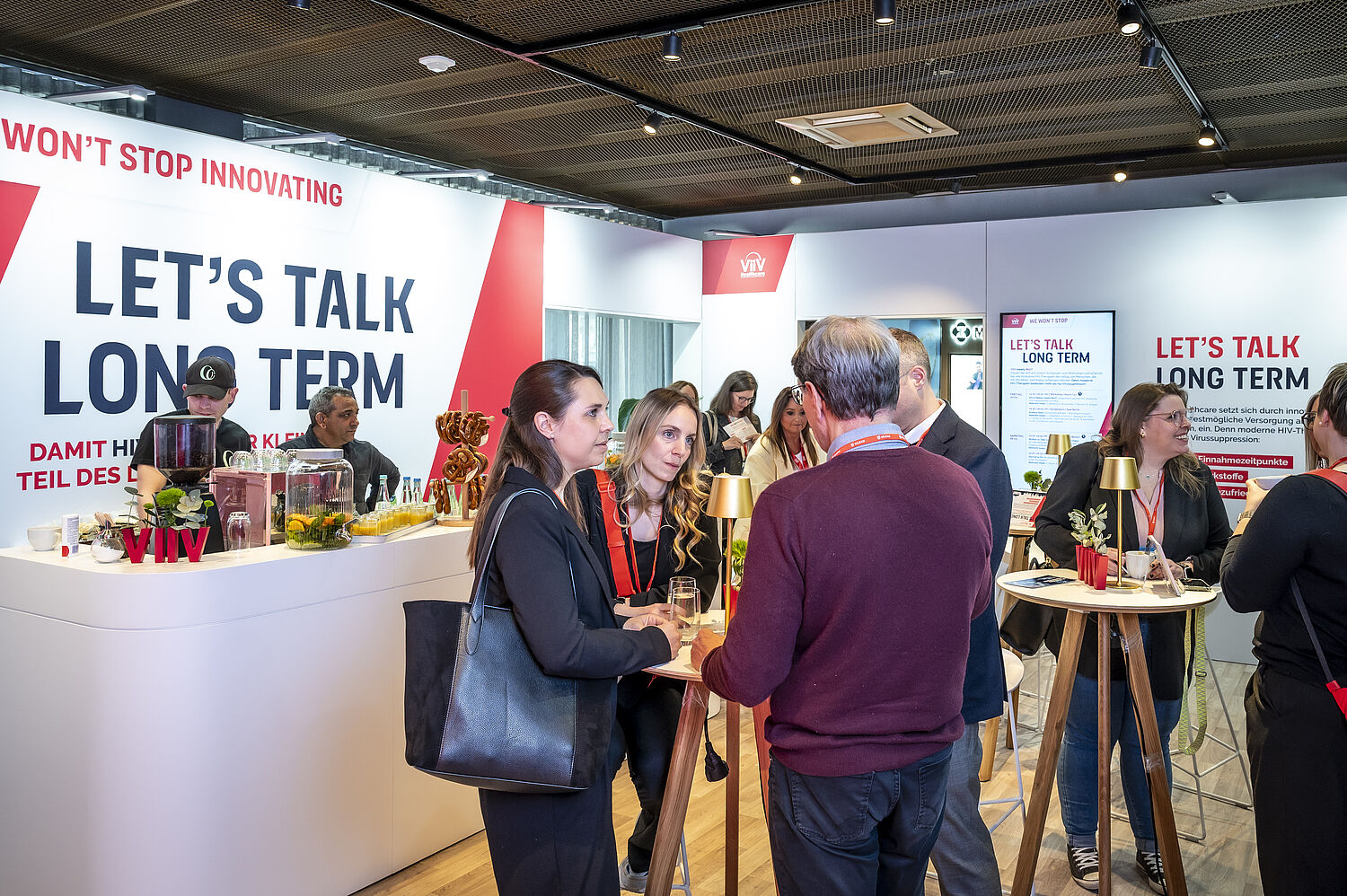 Teilnehmer*innen am Netzwerken im Ausstellerbereich am Stand von ViiV bei den 20. Münchner AIDS- und Infektiologie-Tagen 2026 in Berlin