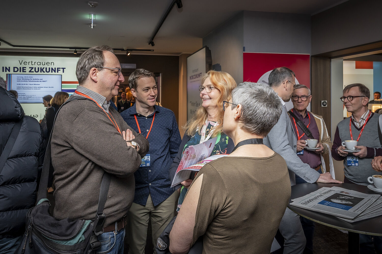 Foto aus dem Austellerbereich bei den 20. Münchner AIDS- und Infektiologie-Tagen 2026 in Berlin. Teilnehmer*innen am Netzwerken