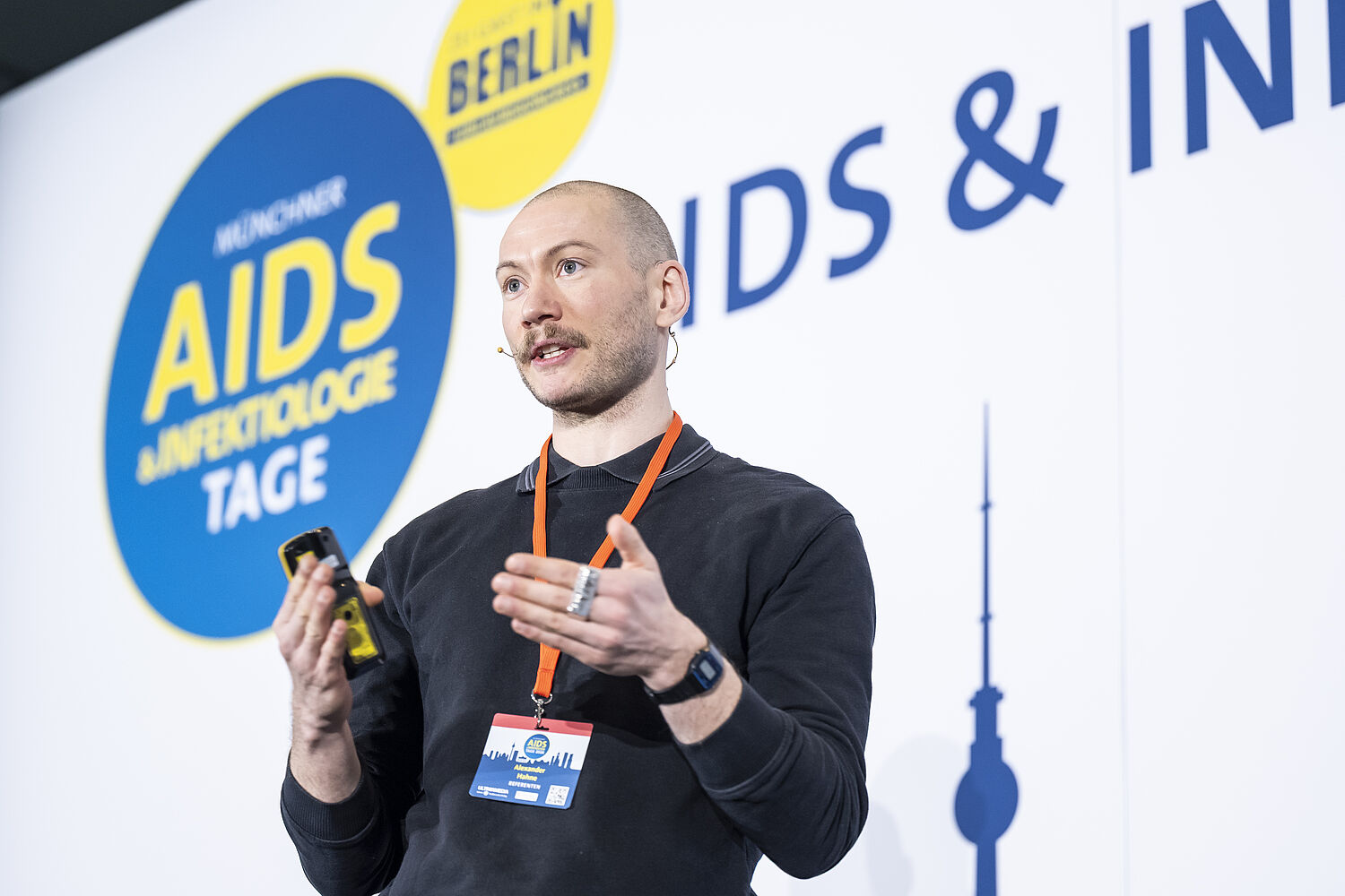 Alexander Hahne spricht auf der Bühne bei den 20. Münchner AIDS- und Infektiologie-Tagen 2026 in Berlin