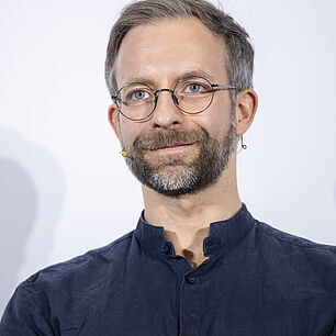 Referent der 20. Münchner AIDS- und Infektiologie-Tagen 2026 in Berlin auf der Bühne während seines Vortrags